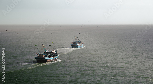 фотографія Traditional fishing boats travel across the open waters off the coast of Pakistan, capturing the scale of coastal fisheries, maritime livelihoods and the timeless rhythm of life at sea