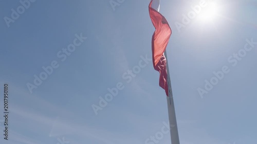 Warsaw skyline from drone with a large Polish flag waving above the city on a clear day