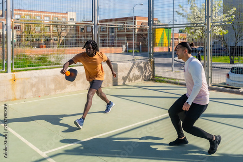 Obraz na plátne Two men playing pickleball on outdoor court