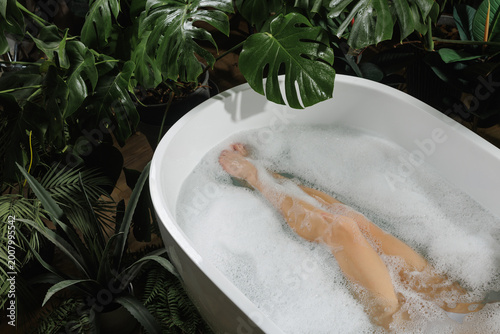 Obraz na płótnie Relaxing Spa Bath Experience with Lush Greenery and Bubbles