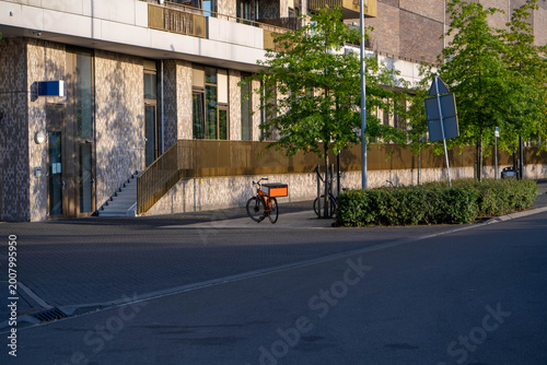 Electric Delivery Bike Parked Outside Modern Apartment Building on Empty City Street