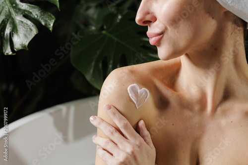 Canvas Print Woman Applying Body Cream in Relaxing Spa Environment