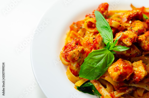 Fotografi Fresh pasta with savory sauce and basil garnish