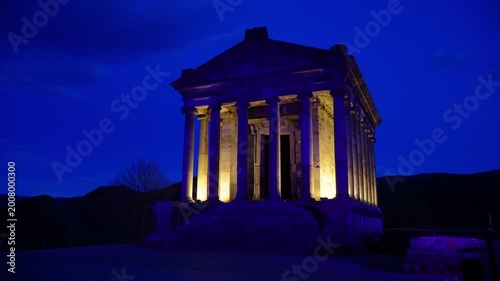 Garni Temple illuminated at dusk in Armenia under blue hour sky