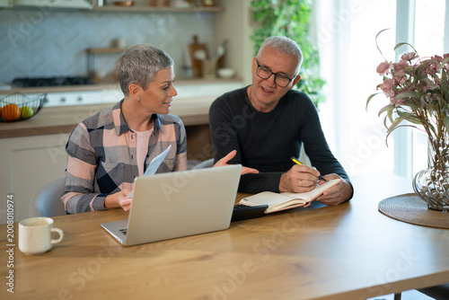 Canvas Print Mature couple managing finances together at home
