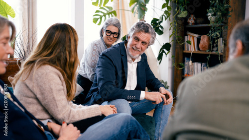 Fotografie Group of seniors friends sitting indoors, having a social gathering and smiling
