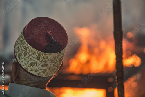 Hand holding traditional staff near fire during Samaritan Passover ritual