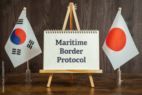 Conceptual image of Maritime Border Protocol shown on notebook with flags. Social awareness and corporate responsibility theme.