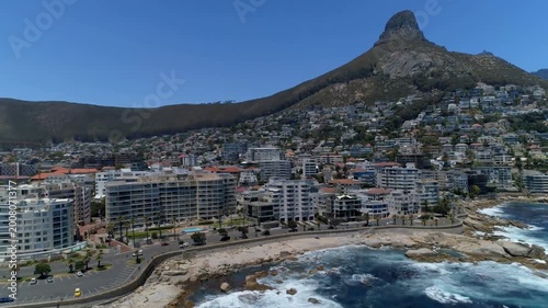 Magenta streak sparking aerial camera gliding and panning, revealing coast, blocks, peak for promo