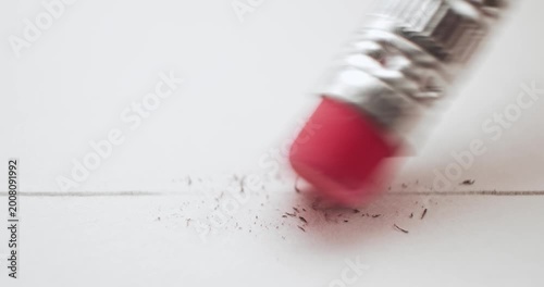 Erasing a pencil line with a pink eraser and creating a mess on white paper. Conceptual bad idea, fixing problems, failure or mistake, wrong decision, or to remove an error. Back to School supplies.