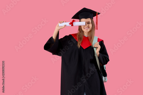 Graduate female student with diploma on pink background. End of school concept