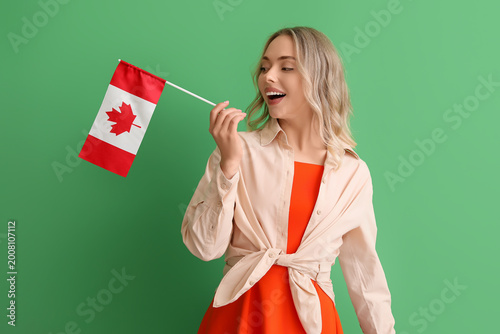 Young woman with flag of Canada on green background