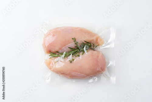 Raw Chicken Breast in Vacuum Sealed Plastic Bag with Rosemary