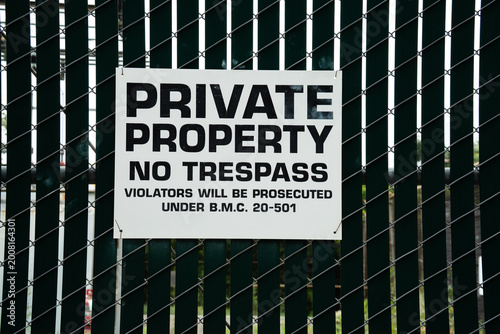 Foto Private property no trespassing sign attached to a chain link fence