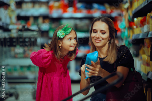 Mother and Daughter Reading Nutrition Label on a Package. Happy mom and child checking food ingredients shopping for healthy foods