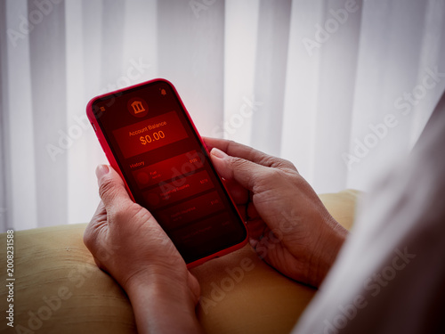 Obraz na plátně Person checking low balance, empty bank account on mobile banking app with red alert screen