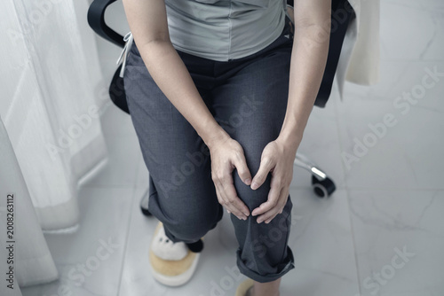 A woman supporting herself from numbness, muscle weakness, pain, and tingling in the knee nerve endings