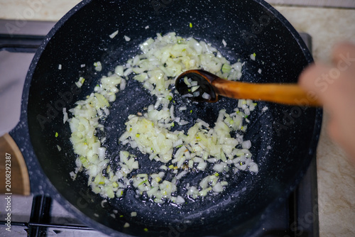 Schilderij op canvas Onion slices caramelizing in hot skillet