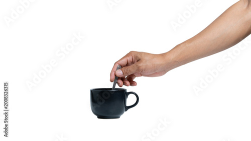 Canvastavla Man's hand holding a black ceramic coffee cup and stirring with a spoon isolated on white background