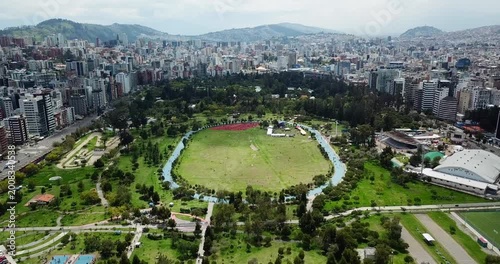 Aerial view of La Carolina Park central field in Quito Ecuador with city skyline in background