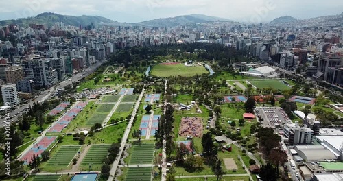 Aerial forward flyover of La Carolina Park and Quito skyline Ecuador