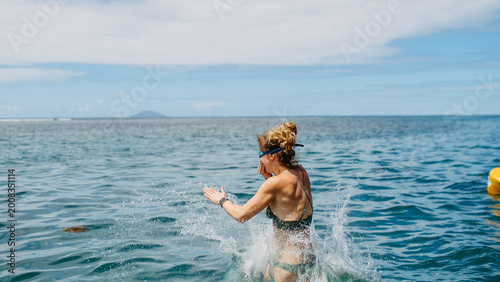 Canvas Print Woman jumping into sea water and splashing, summer vacation.