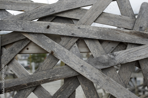 Photography Wooden fence made up of boards arranged in a crisscrossing pattern