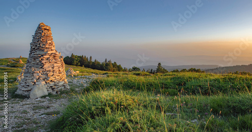 large mountain cairn in a beautiful landscape during a sunset in colorful sky...