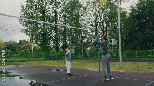 Father and daughter enjoy playful moment practicing volleyball outdoors. Man teaching daughter to play volleyball outdoors. Family day. 4K, UHD