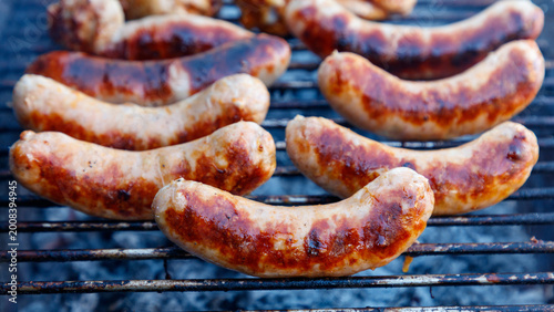 Schilderij op canvas Close-up of grilled sausages on a metal barbecue grill