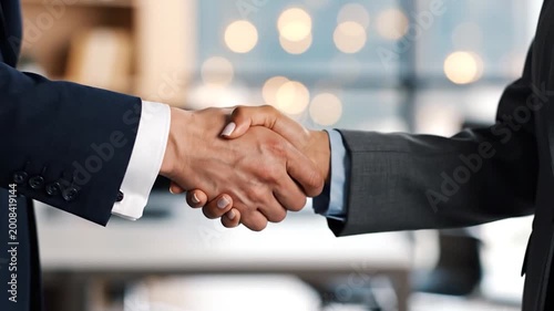 Two business people shaking hands in an office setting, symbolizing agreement and cooperation for a successful partnership deal