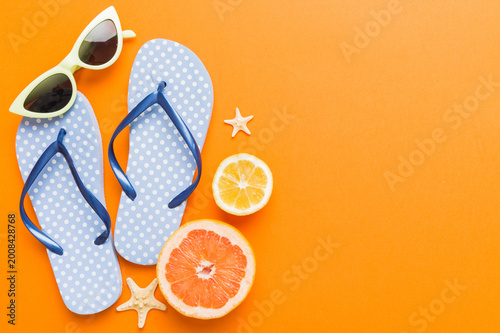 Top view composition of flip flops placed with beach accessories top view on table background. Tropical summer vacation concept Flat lay