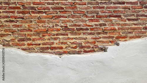 Old Red Brick Wall with Peeling White Plaster Texture and Cracked Surface, Industrial Vintage Background, Weathered Building Exterior Showing Aged Masonry for Renovation and Construction Concepts.