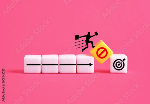 Businessman jumping over obstacle to reach target avoiding prohibition sign