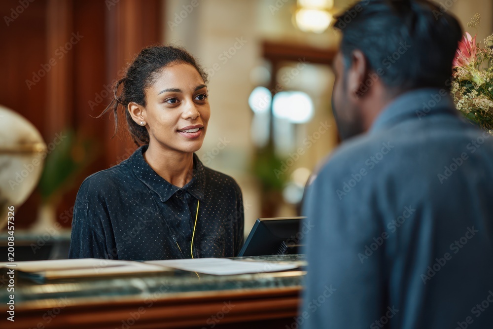 Fototapeta premium African female hotel receptionist smiling at guest