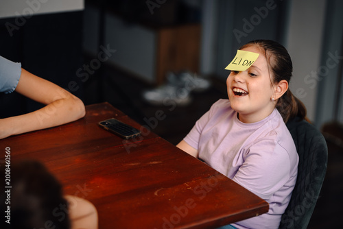 Billede på lærred Young child laughing playing guessing game at home