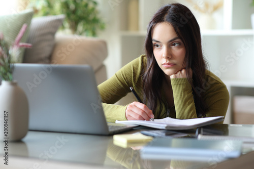 Concentrated student taking notes of online content