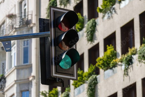 Quadro su tela Close-up of green traffic light on urban street with modern residential building