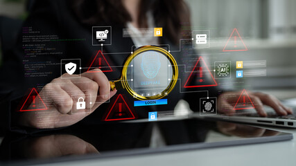A professional woman uses a magnifying glass to analyze cybersecurity visuals, highlighting important data, alerts, and security measures in a modern office environment. Ledger
