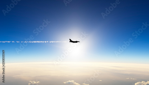 Fighter jet silhouette flying high in blue sky with contrail
