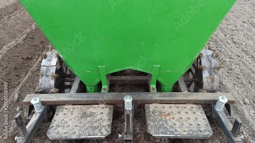 Modern Green Potato Planter Machine Working on Freshly Cultivated Soil ensures efficient planting. This agricultural equipment precisely opens furrows in the ground. It is essential for farm work
