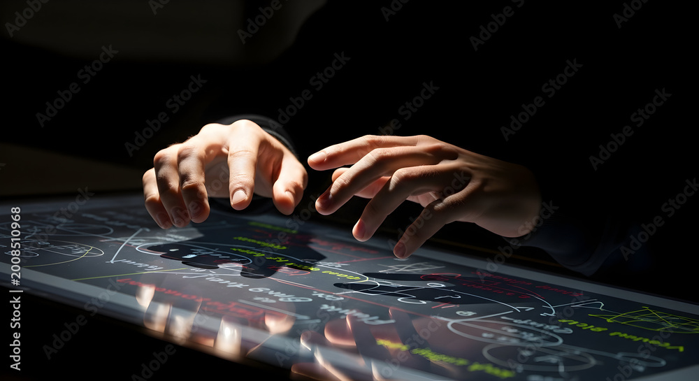 Naklejka premium Close-Up of Hands Interacting with a Digital Touch Screen Display in a Darkened Room With Colorful Data Visualizations and High-Tech Interface Elements