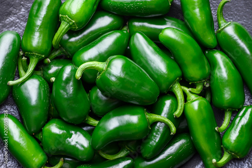 Foto Pile of fresh jalapeno peppers with rustic knife on wooden table