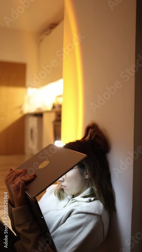 Vertical screen exhausted young woman sitting on floor with laptop eyes closing from fatigue losing focus and drifting into sleep after long study session overwhelmed by mental overload