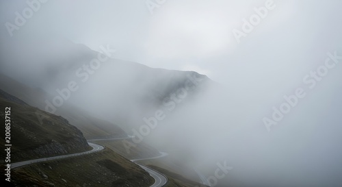 Misty mountain pass road winding through fog and clouds on a dramatic, scenic journey