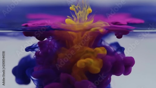 Close-up abstract of blue liquid mixing with clear water creating smoky patterns and delicate bubbles showing fluid dynamics and vibrant colors with a clean background
