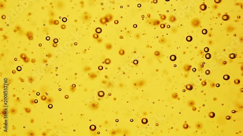Macro shot of sunflower oil bubbles on golden background, abstract liquid texture, cooking ingredient detail, fluid pattern design.