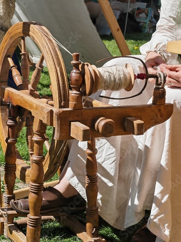 Woman spinning wool using a traditional wooden spinning wheel