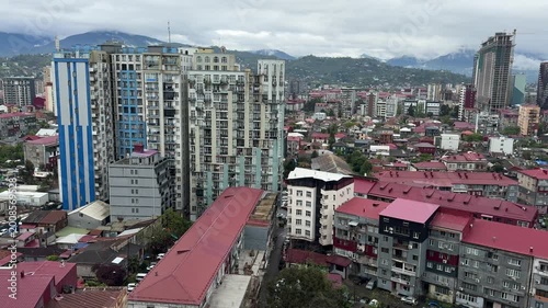 Panoramic view of modern residential architecture with vibrant skyscrapers against a majestic mountain range in Georgia. Urban landscape concept.