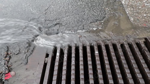 Stockholm, Sweden Heavy rain falls on a street and runs down a storm drain. 